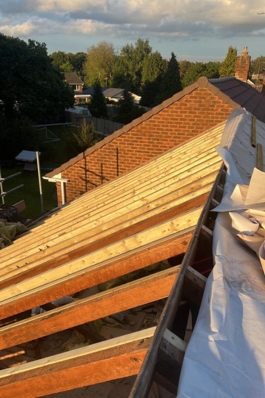 A roof with the tiles removed and the beams exposed.